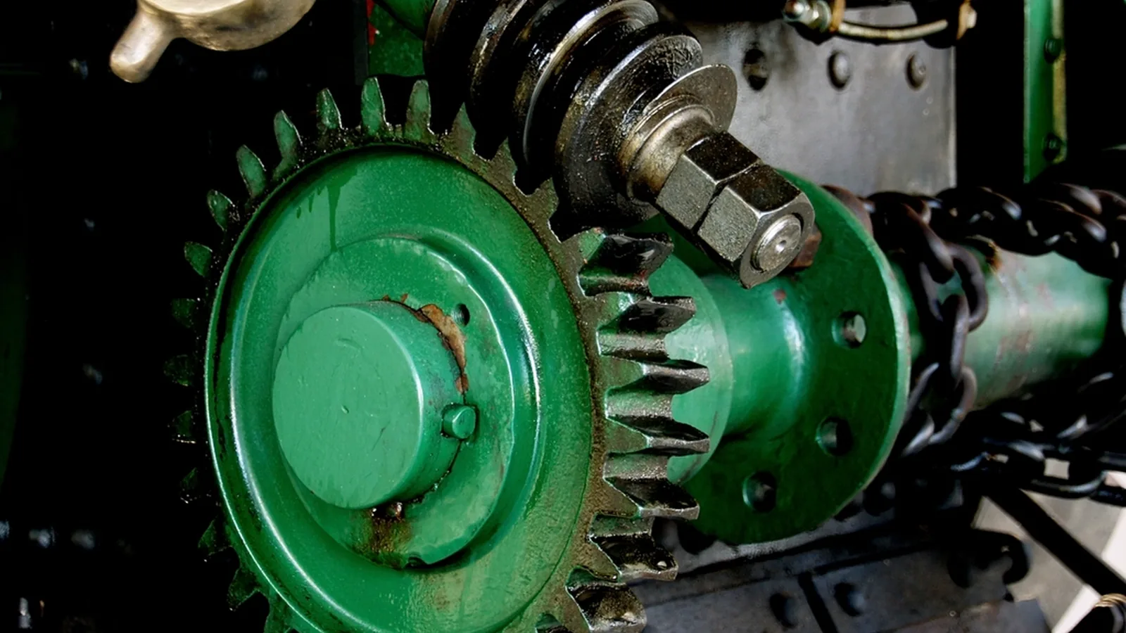 Close-up of green industrial gears and cogs meshing together
